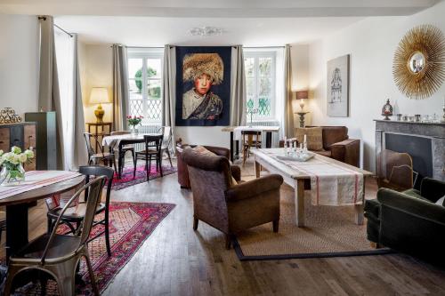 un salon avec mobilier et peinture d'un homme dans l'établissement Villa Marguerite Chambres et Table d Hotes de charme, à Cadouin