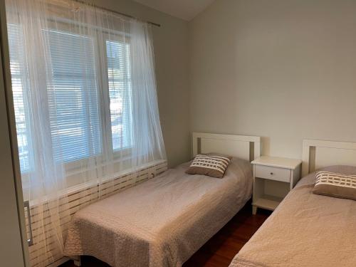 een slaapkamer met 2 bedden en een raam bij Rauhan Marinella Apartments in Imatra