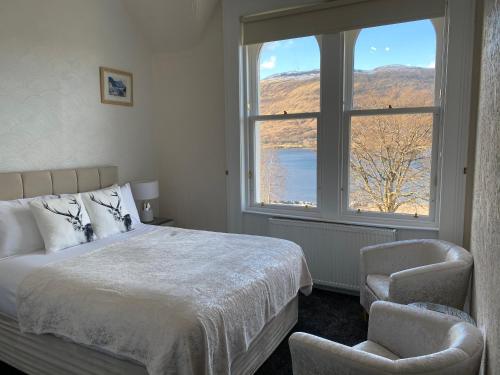 a bedroom with a bed and a window and a chair at Ashburn House in Fort William