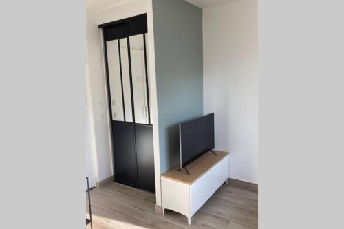 - une télévision assise sur une table dans l'établissement Appartement cosy proche RER et centre ville, au Plessis-Robinson