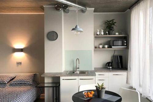 - une cuisine avec un évier et une table dans une chambre dans l'établissement Bangu apartment with TERRACE in old town, à Klaipėda