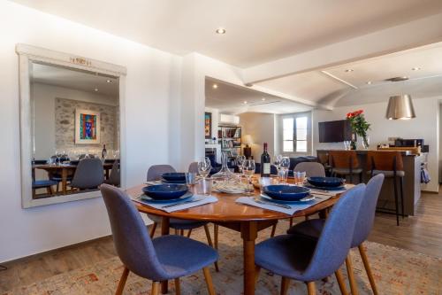 une salle à manger avec une table et des chaises en bois dans l'établissement Charmant appartement spacieux pour 6P vue mer vieil Antibes, à Antibes