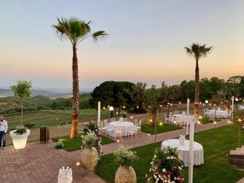 a wedding reception with white tables and palm trees at Agriturismo Vecchia Masseria Charme&Relax in San Michele di Ganzaria