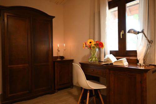 a home office with a desk with a vase of flowers at Agriturismo Vecchia Masseria Charme&Relax in San Michele di Ganzaria