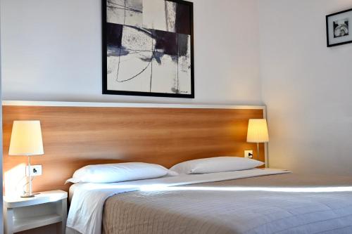 a bedroom with a bed with a wooden headboard and two lamps at Agriturismo Vecchia Masseria Charme&Relax in San Michele di Ganzaria