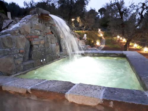 una cascata in una piscina con fontana di Romantic house with outside hydro a Montecatini Terme