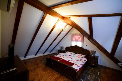 ein Schlafzimmer mit einem Bett im Dachgeschoss in der Unterkunft Green Paradise in Donje Gredice