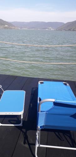 a blue chair sitting on the deck of a boat at Casa Laura in Orşova