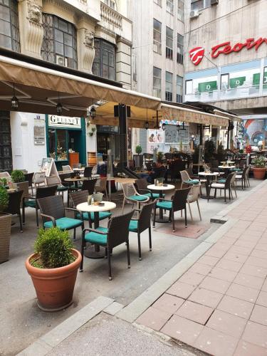 un restaurante al aire libre con mesas y sillas en una ciudad en Apartment My Home, en Belgrado