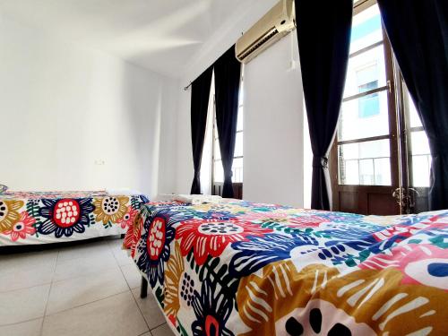 a bedroom with two beds with colorful sheets at Arc House Ribera Only Adults in Córdoba