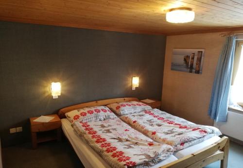 a bedroom with a large bed with red and white blankets at Hotel Alpenrose in Maienfeld