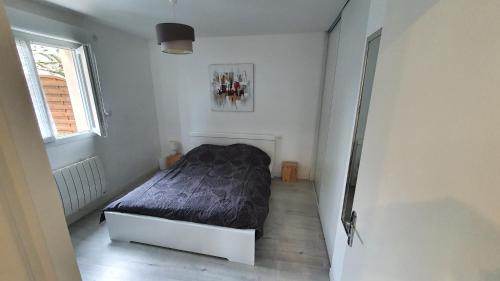 ein Schlafzimmer mit einem Bett in einem weißen Zimmer in der Unterkunft pepiniere in Nogent-sur-Seine