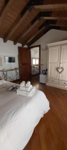 a bedroom with a large white bed with wooden floors at B&B Casa del Teatro in Mantova