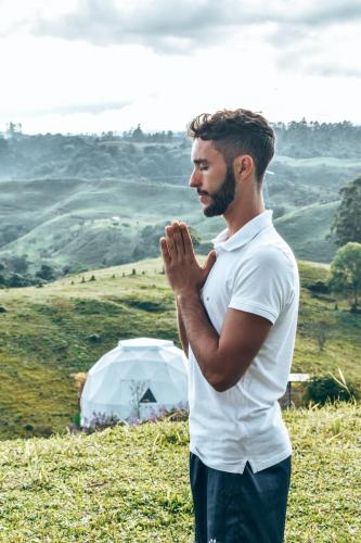 a man is standing in front of a tent at Ecohotel Monte Tierra Habitaciones y Glamping in Filandia