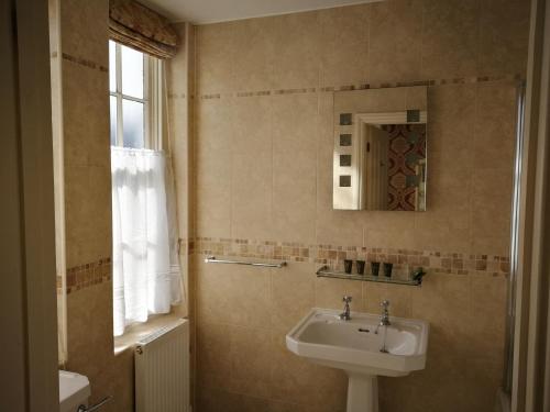 a bathroom with a sink and a mirror at Feathers Royal Hotel in Aberaeron