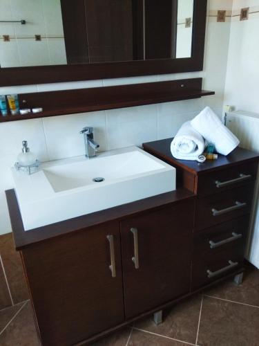 a bathroom with a white sink and a mirror at Marmari MEGALI AMMOS MAISONETTE in Marmarion
