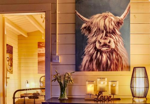 a painting of a cow on a wall with candles at Sunset log cabin in Sudbury