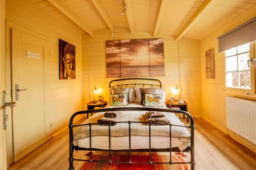 a bedroom with a bed in a room with yellow walls at Sunset log cabin in Sudbury