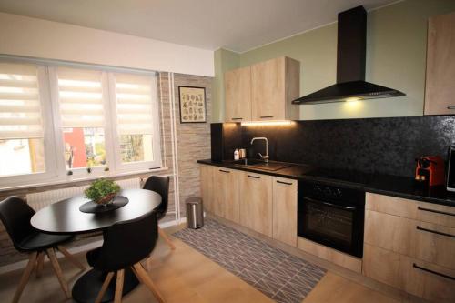 - une cuisine avec une table, une cuisinière et un comptoir dans l'établissement Appartement tout confort, meublé et équipé., à Sarreguemines