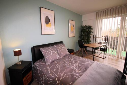 サルグミーヌにあるAppartement tout confort, meublé et équipé.のベッドとテーブルのある寝室とダイニングルーム