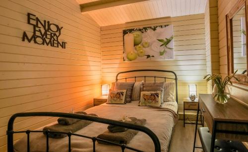 een slaapkamer met een bed in een houten muur bij The Retreat Log Cabin in Sudbury