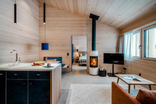 a kitchen and living room with wooden walls and a fireplace at Fuchsegg Eco Lodge in Egg