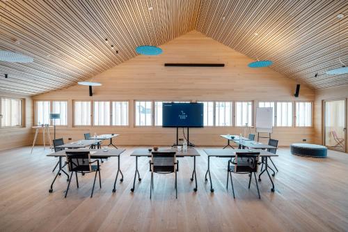 a large room with tables and chairs and a tv at Fuchsegg Eco Lodge in Egg