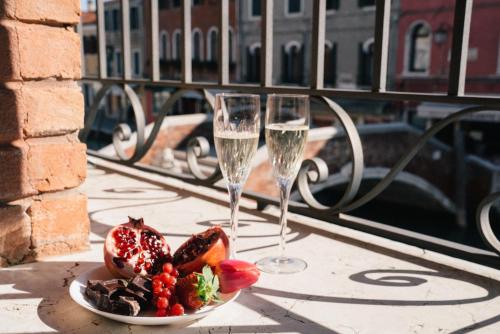 une assiette de nourriture et deux verres de champagne dans l'établissement Murano Palace, à Murano