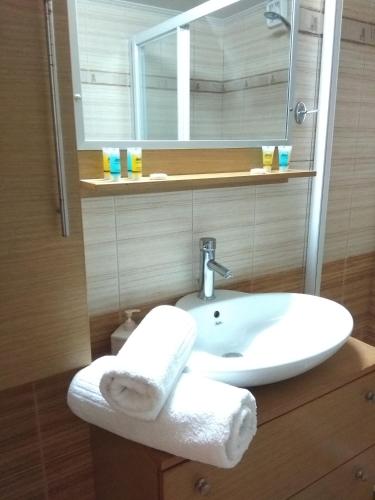a bathroom with a sink and a mirror at Marmari MEGALI AMMOS MAISONETTE in Marmarion