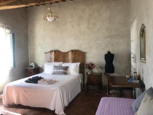 a bedroom with a white bed with a wooden headboard at B&B Podere Camaiano in Roccastrada