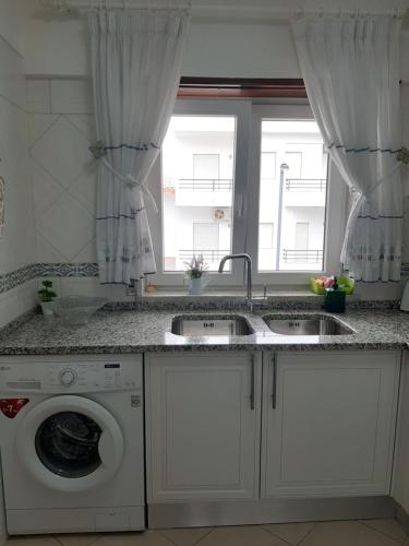 a kitchen with a sink and a washing machine at Beach Falésia in Albufeira