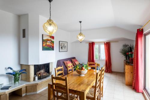 a dining room with a table and a fireplace at Residence Helios in Cargèse