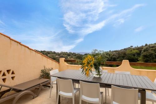 a patio with a table and chairs on a balcony at Residence Helios in Cargèse
