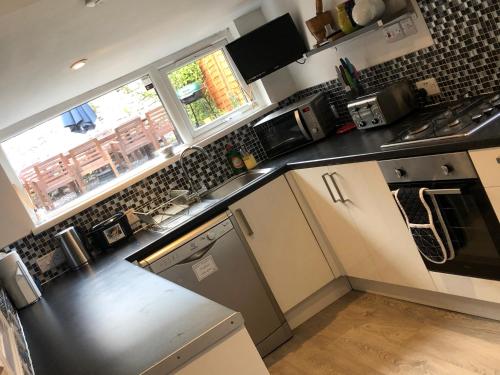 a kitchen with a black and white counter top at City Centre Victorian Terrace in Cardiff