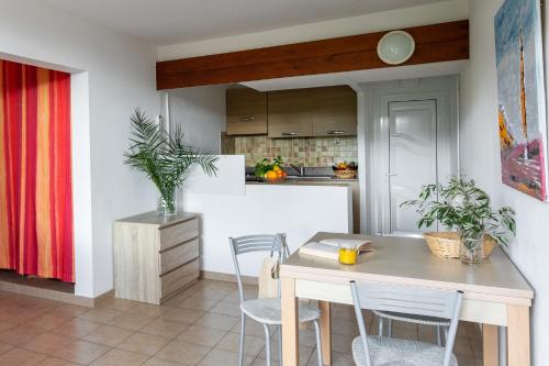 a kitchen and dining room with a table and chairs at Residence Helios in Cargèse