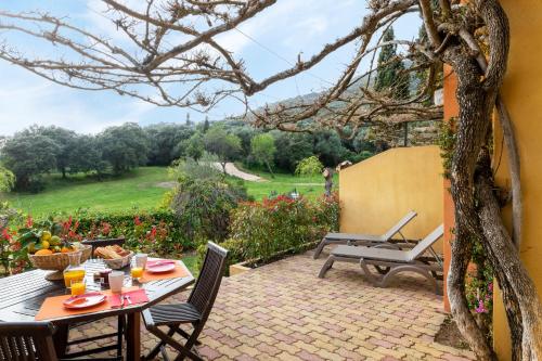 a patio with a table and chairs with a view at Residence Helios in Cargèse
