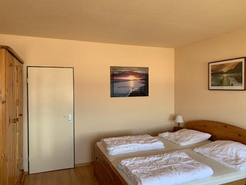 1 dormitorio con 2 camas individuales y espejo en Südstrandwohnung en Fehmarn