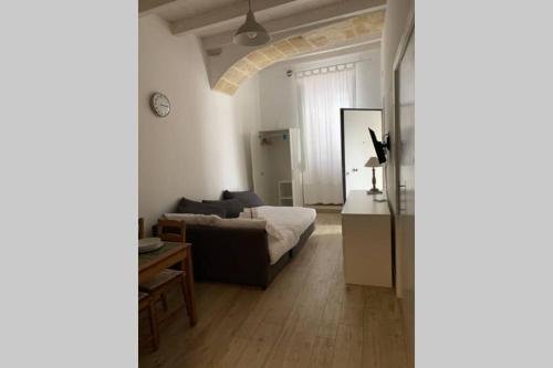a bedroom with a bed and a living room at casa morola Monolocale in Trani