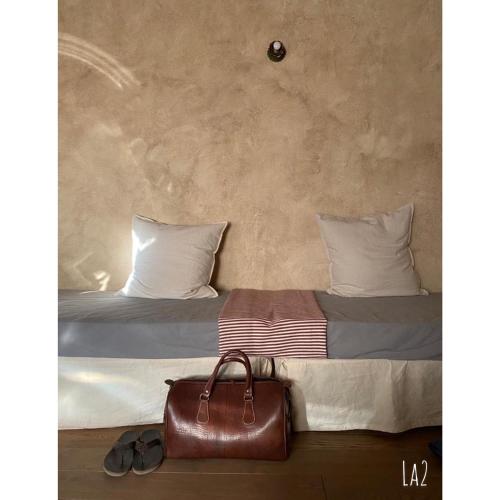 a bedroom with a bed with a brown leather bag at B&B Podere Camaiano in Roccastrada