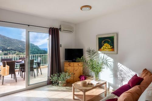 a living room with a couch and a balcony at Residence Helios in Cargèse
