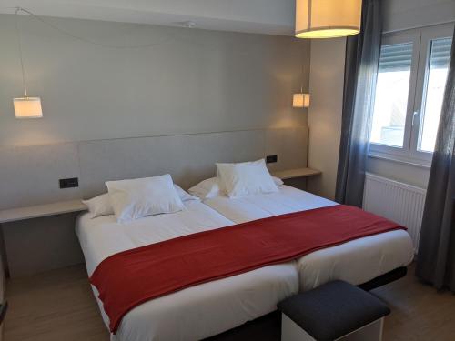 a bedroom with a large bed with a red blanket at Seijo in Villalba
