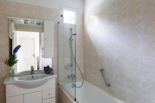 a bathroom with a sink and a shower and a tub at Residence Helios in Cargèse