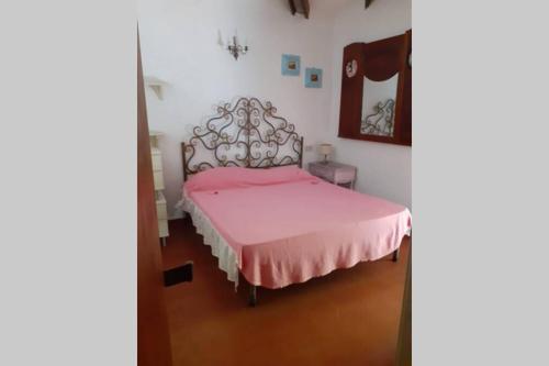 a bedroom with a pink bed and a mirror at Casa Charming immersa nel verde in Forte dei Marmi