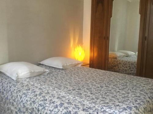 a bedroom with a bed with two pillows and a mirror at Le 5 d'Abel in Mornac