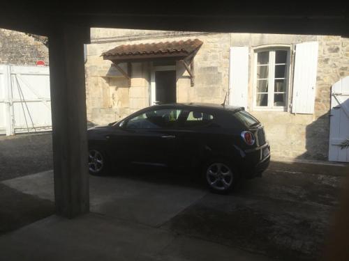 a black car parked in front of a house at Le 5 d'Abel in Mornac