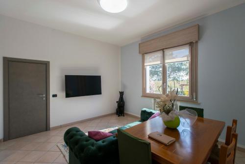 Eco Dolce Casetta B&B في فاينسا: غرفة معيشة مع طاولة طعام وتلفزيون
