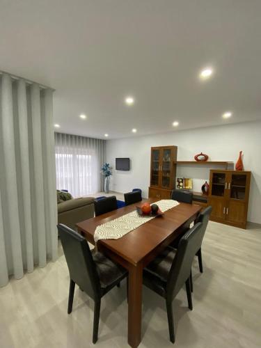 a living room with a wooden table and chairs at Gina House in Nazaré