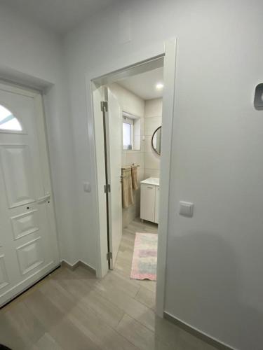 a bathroom with a white door and a sink at Gina House in Nazaré