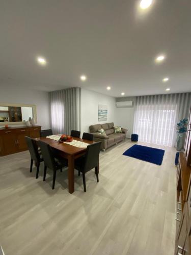 a living room with a table and chairs and a couch at Gina House in Nazaré