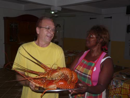 a man and a woman holding a large lobster at Villa Mancina in Capesterre-Belle-Eau